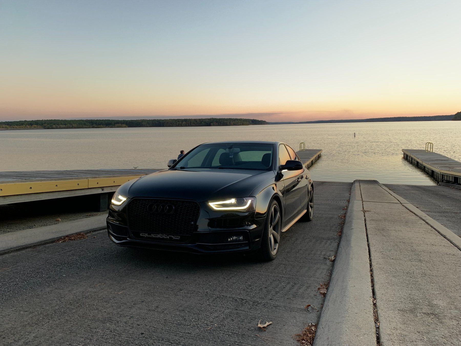 Freshly detailed black Audi beside the water at sunset